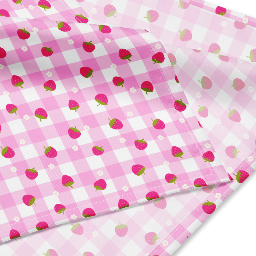 Pink gingham bandana with small strawberry pattern scattered across checkered background in cute ditsy style