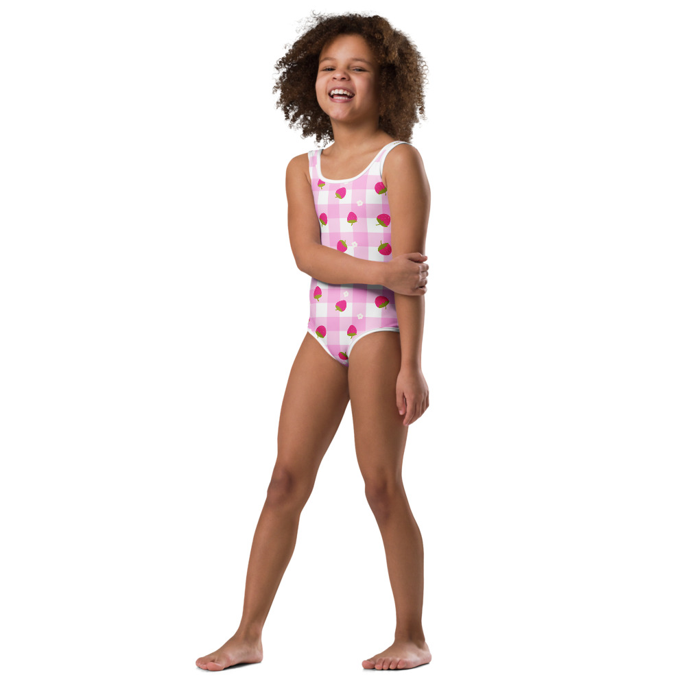 Kids swimsuit featuring pink gingham pattern with small strawberry ditsy print design in cute checkered style
