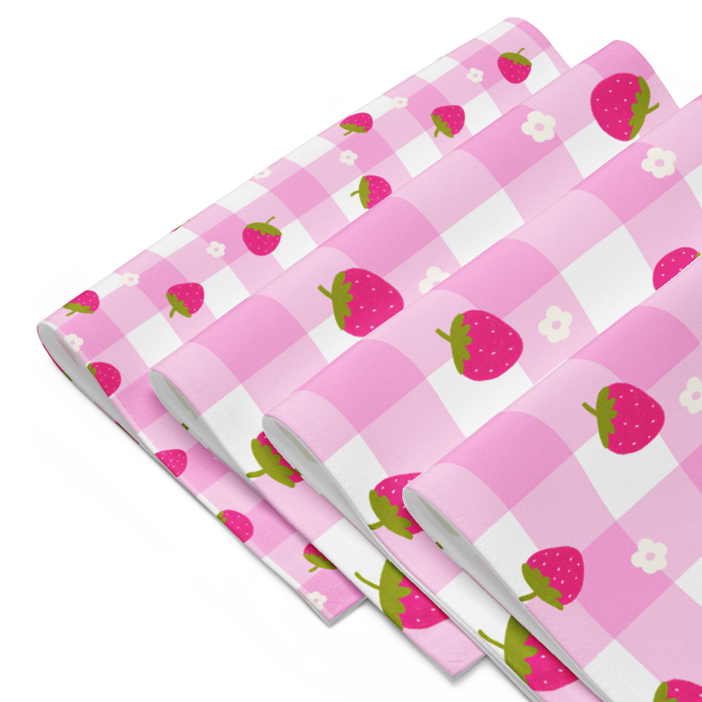 Set of four pink gingham placemats with scattered strawberry pattern, showing classic checkered design with fruit motifs